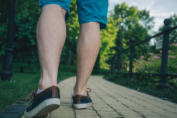 Photo recadrée d'un jeune homme marchant dans le parc — Photo