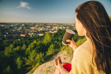tepenin zirvesine oturan genç güzel kadın