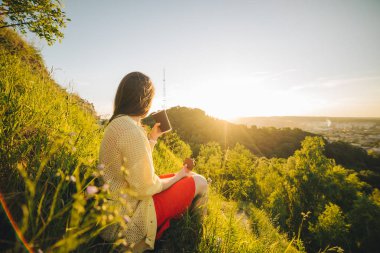 tepenin zirvesine oturan genç güzel kadın