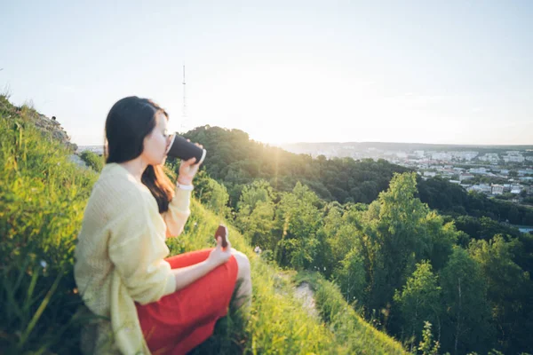 Jovem mulher bonita sentado no pico da colina — Fotografia de Stock