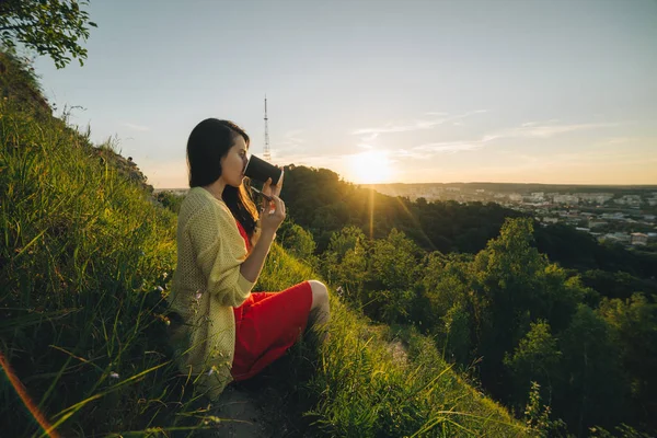 Young pretty woman sitting on the peak of the hill — Stock Photo, Image