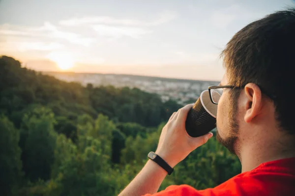 Man sitting on the top of the hill with cup of coffee — Stock Photo, Image