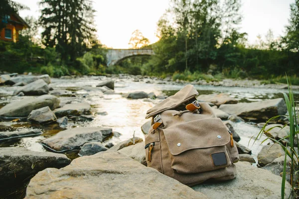 Рюкзак біля гір річка — стокове фото