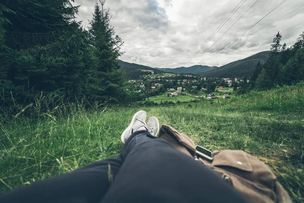 男は地面に横たわって、山の景色を楽しみながら — ストック写真