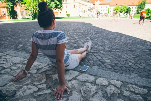 Joven bonita mujer sentada en el suelo descansando después de un largo paseo —  Fotos de Stock