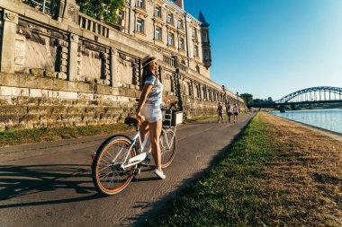 güzel kadın binmek bisiklet setin Wisla Nehri üzerinde