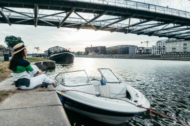 sabah iskelede oturan şapkalı genç güzel kadın