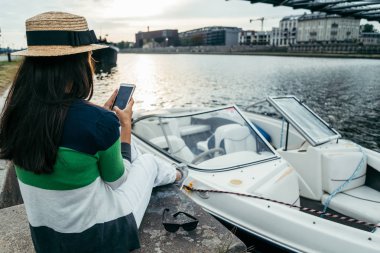 sabah iskelede oturan şapkalı genç güzel kadın