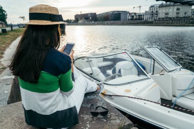 sabah iskelede oturan şapkalı genç güzel kadın