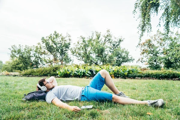 사람이 음악을 나열 하는 잔디에 누워 — 스톡 사진