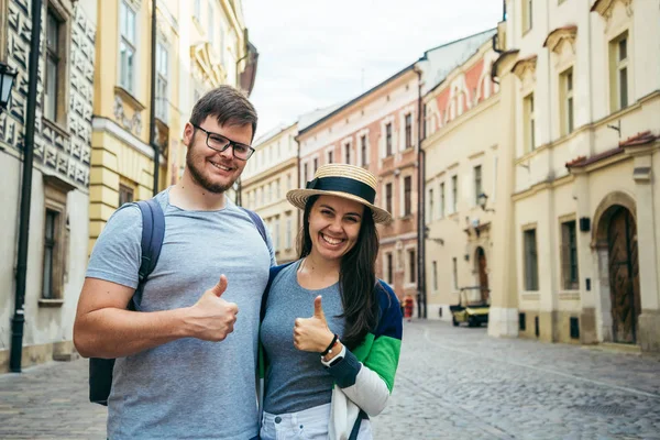 Cuplu stand cu degetul mare în sus pe strada europeană veche — Fotografie, imagine de stoc