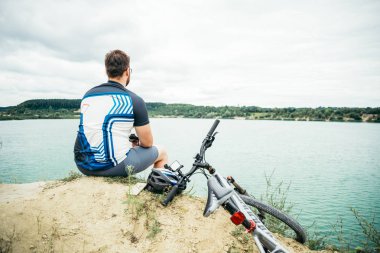 adam bisiklet ile tepenin zirvesine oturan ve görünümü resim çekmek