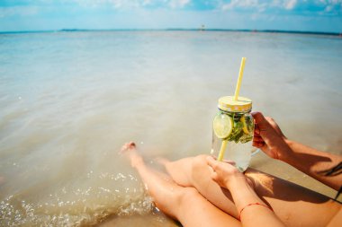 mojito kadın bacakları yakınındaki plajda bardak