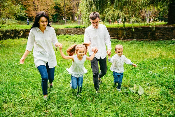 Familia feliz corriendo en el parque de la ciudad —  Fotos de Stock