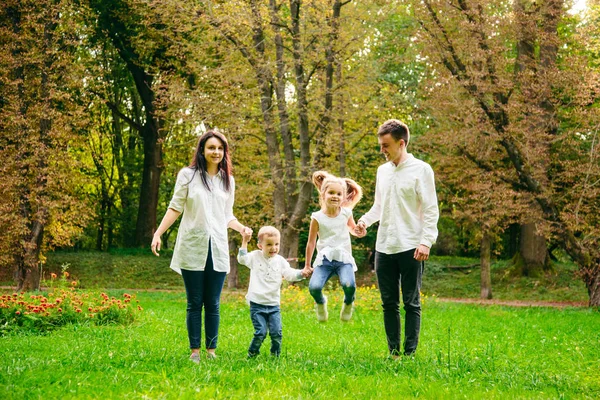 Щаслива сім'я біжить в міському парку — стокове фото