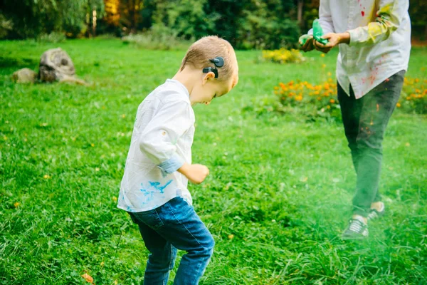 Niño con audífono jugando con pinturas holi — Foto de Stock