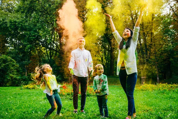 Linda familia europea trenzado con pinturas holi en el parque —  Fotos de Stock