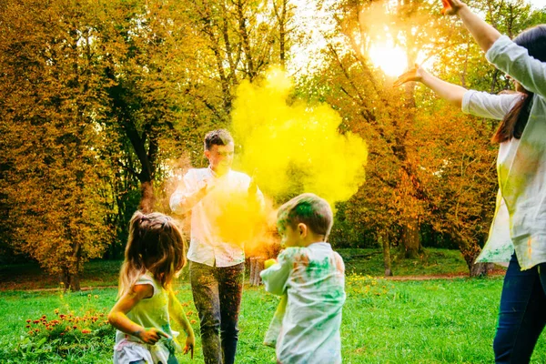 Linda familia europea trenzado con pinturas holi en el parque —  Fotos de Stock