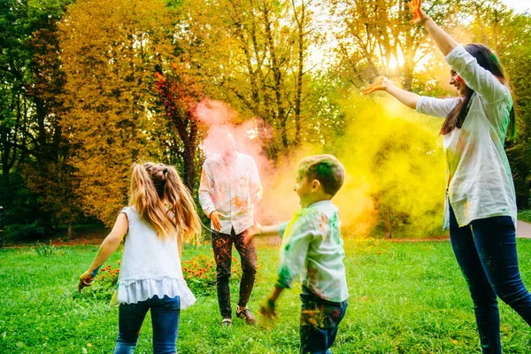 Linda familia europea trenzado con pinturas holi en el parque —  Fotos de Stock