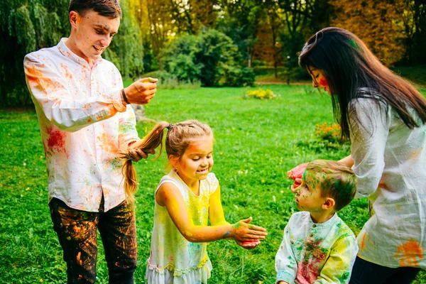 Linda familia europea trenzado con pinturas holi en el parque —  Fotos de Stock