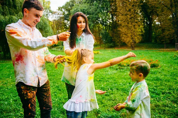 Linda familia europea trenzado con pinturas holi en el parque —  Fotos de Stock