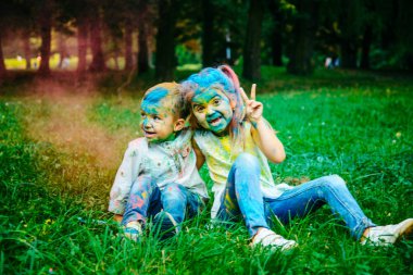 küçük çocuk kızla oturacak tüm kirli holi boyalar