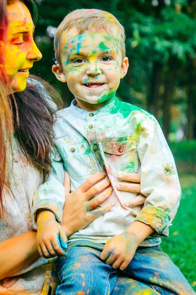 Madre con hijo en pinturas holi en el parque de la ciudad —  Fotos de Stock