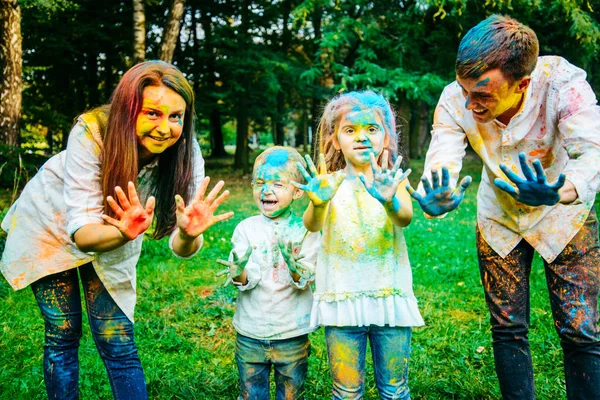 Familia feliz pálido con pinturas holi en el parque de la ciudad —  Fotos de Stock