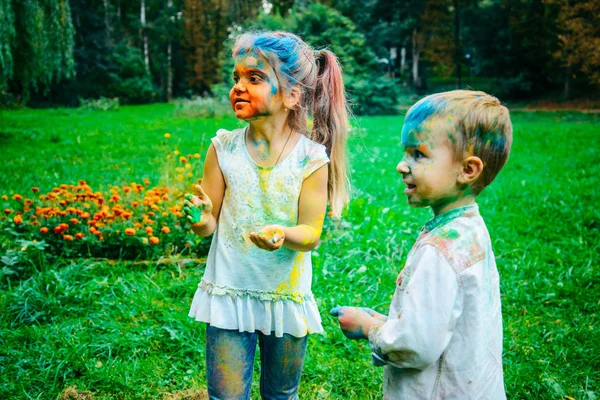 küçük çocuk kızla oturacak tüm kirli holi boyalar