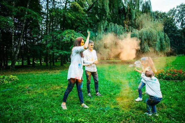 Familia feliz pálido con pinturas holi en el parque de la ciudad —  Fotos de Stock