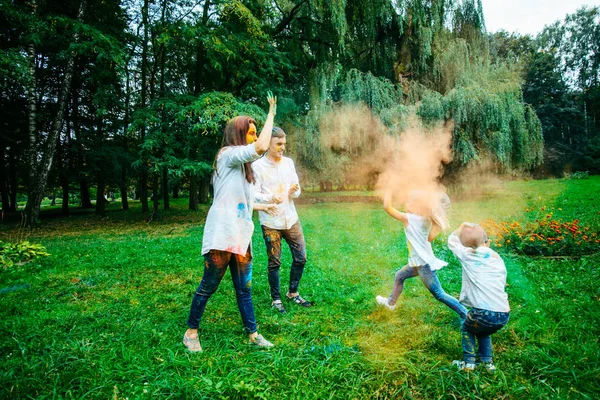 Familia feliz pálido con pinturas holi en el parque de la ciudad —  Fotos de Stock