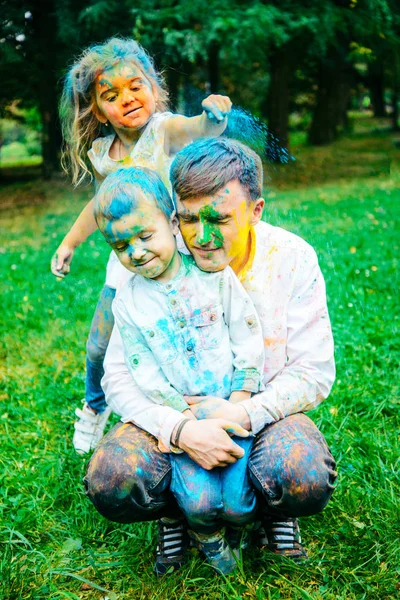 Батько з дітьми брудний від голлі фарб — стокове фото