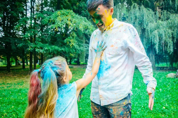 Padre con hija jugar en parque con pinturas holi — Foto de Stock