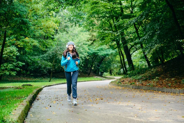 Νεαρή όμορφη γυναίκα τρέχει ωτερικής στο πάρκο — Φωτογραφία Αρχείου