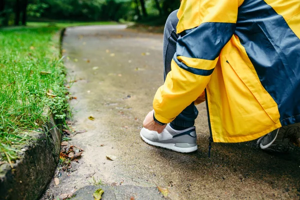 Concetto corsa e sport.Sportsman mani allacciatura lacci delle scarpe . — Foto Stock