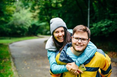 Çift spor giyim gülüyor, kadın atlamak adam omuzlarında