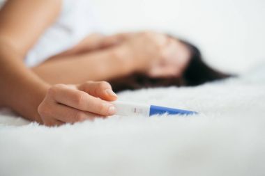 Kadın üzgün negatif hamilelik testi ile yatakta yalan