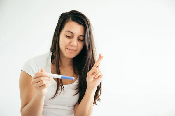 Ung kvinna tittar på pregnance test i lycka — Stockfoto