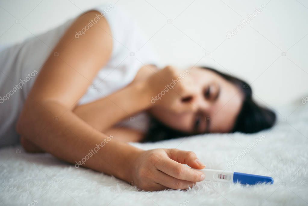 sad woman with pregnancy test