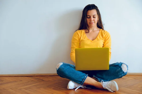 Jovem mulher bonita sentada no chão com laptop — Fotografia de Stock