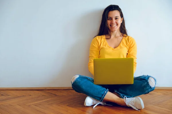 Jovem mulher bonita sentada no chão com laptop — Fotografia de Stock