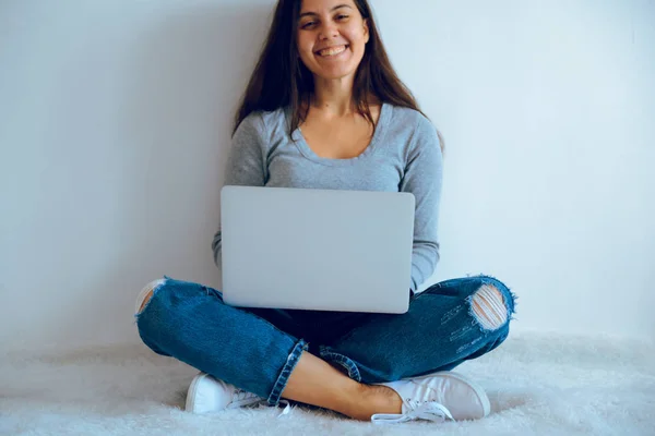 Jovem mulher bonita sentada no chão com laptop — Fotografia de Stock