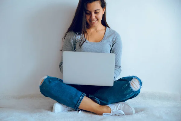 Jovem mulher bonita sentada no chão com laptop — Fotografia de Stock