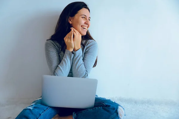 Mujer bonita joven sentada en el suelo con el ordenador portátil — Foto de Stock