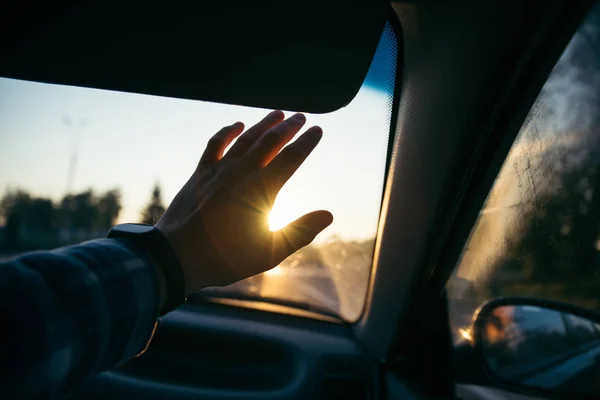 Homme tenir la main devant le soleil au coucher du soleil — Photo