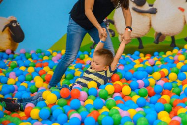 Bir çocuk annesi birçok küçük renkli topları ile oyun odası ile