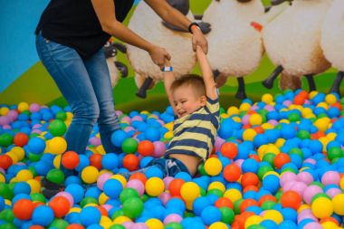 Bir çocuk annesi birçok küçük renkli topları ile oyun odası ile