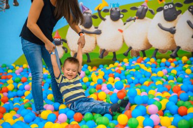 Bir çocuk annesi birçok küçük renkli topları ile oyun odası ile