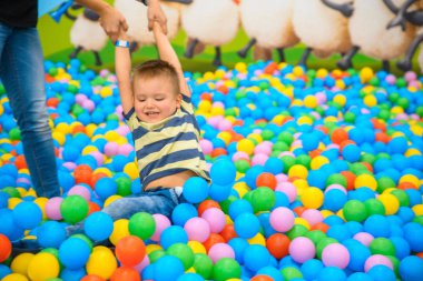 Bir çocuk annesi birçok küçük renkli topları ile oyun odası ile