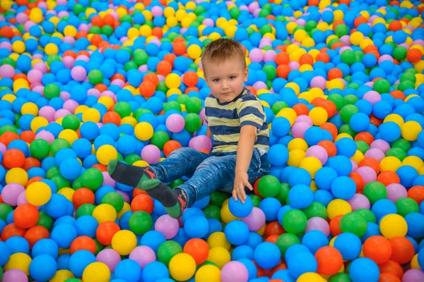 Birçok küçük renkli topları ile oyun odasında bir çocuk